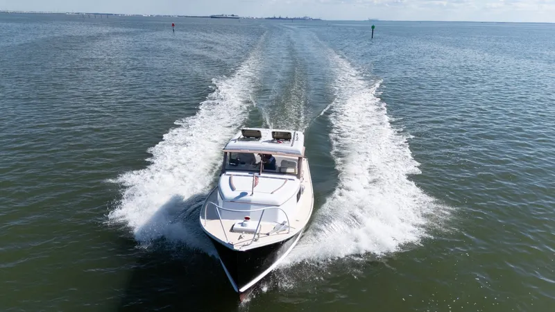 Slide: The Image of A 1959 Dyer 29 Trunk Cabin boat speeds across the water, leaving a white wake behind. - 49