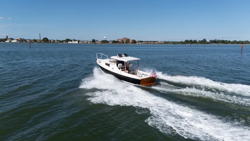 Slide: The Image of A 1959 Dyer 29 Trunk Cabin boat cruising on calm waters, featuring an American flag. - 40