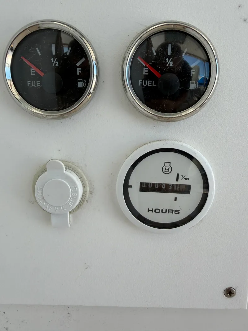 Slide: The Image of Two fuel gauges and an hour meter on a white dashboard. - 20