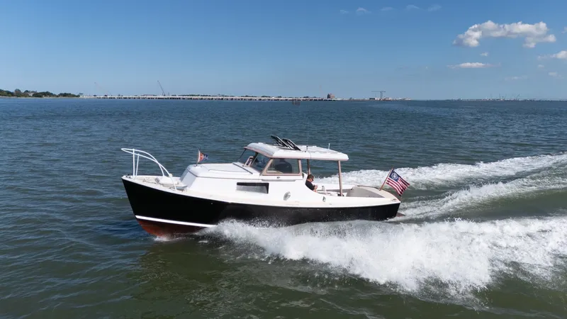 Slide: The Image of A 1959 Dyer 29 Trunk Cabin boat cruising on the water with an American flag. - 45