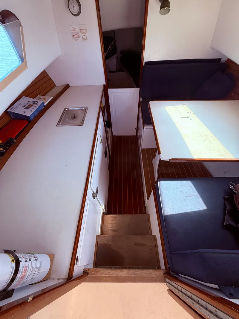 Slide: The Image of Interior of a 1959 Dyer 29 Trunk Cabin with seating area and small kitchenette. - 31