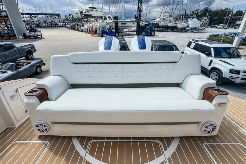 Slide: The Image of 2027 Tiara Yachts 39 LS luxury seating on deck, surrounded by parked vehicles and boats. - 32