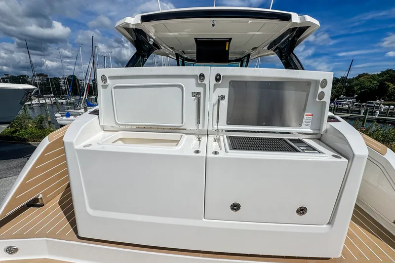 Slide: The Image of 2027 Tiara Yachts 39 LS outdoor kitchen with grill and storage, docked at marina. - 29