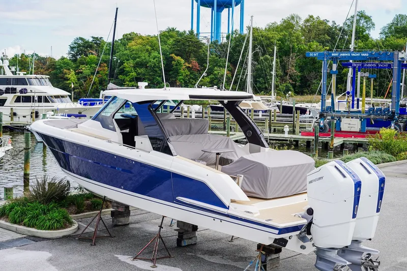 Slide: The Image of 2027 Tiara Yachts 39 LS in marina, blue hull, twin Mercury outboards, covered seating. - 5