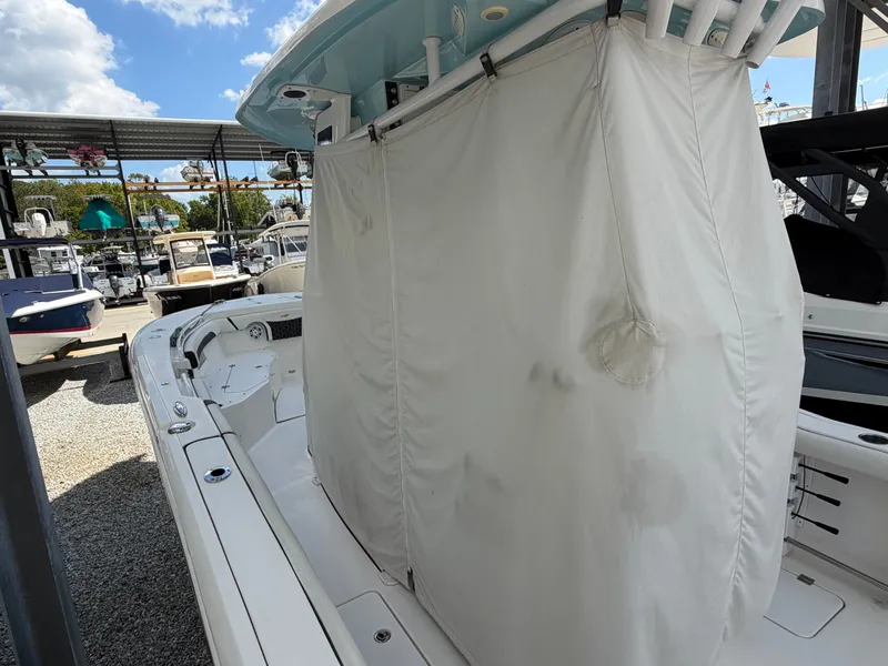 Slide: The Image of A 2021 Tidewater 272 CC Adventure with a cover in the cockpit area, surrounded by other boats. - 17