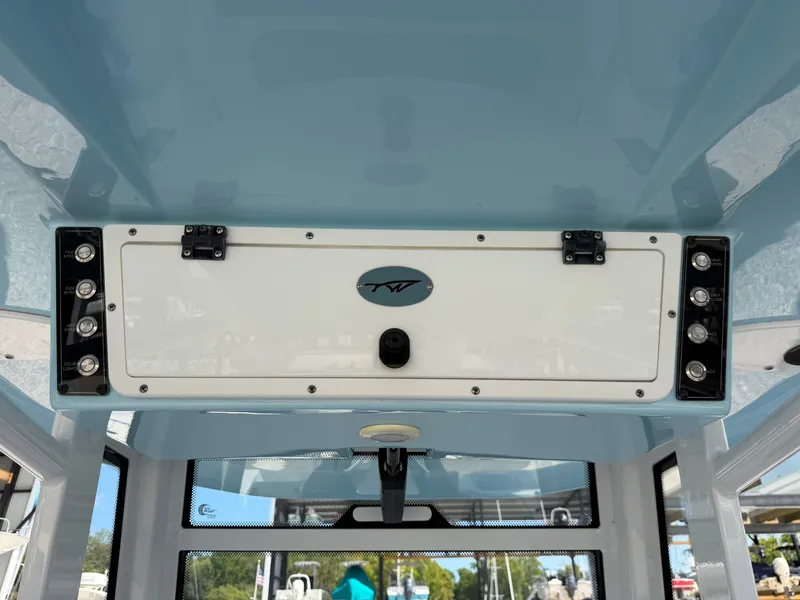 Slide: The Image of The image shows the helm of a 2021 Tidewater 272 CC Adventure boat with a blue ceiling. - 49