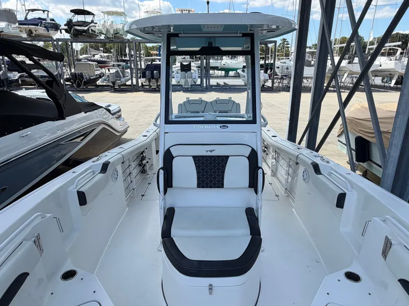 Slide: The Image of The image shows the cockpit of a 2021 Tidewater 272 CC Adventure boat docked in a marina. - 33