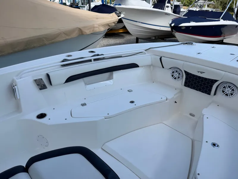 Slide: The Image of The image shows the cockpit of a 2021 Tidewater 272 CC Adventure boat with white seating. - 32