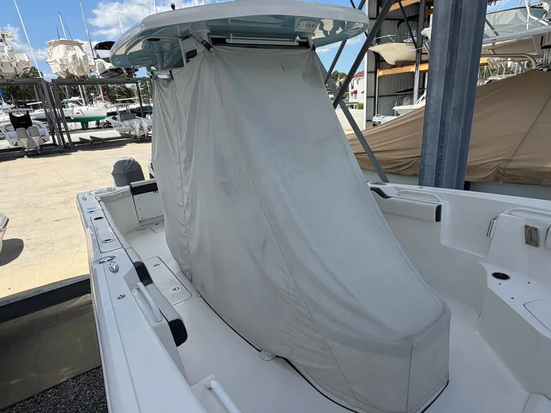 Slide: The Image of A 2021 Tidewater 272 CC Adventure with a cover in the cockpit area, located in a marina. - 21