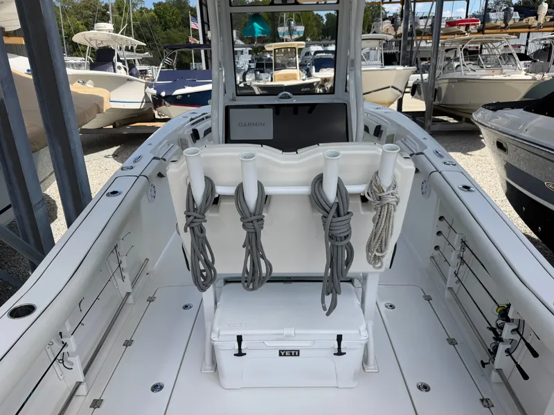 Slide: The Image of The image shows the cockpit of a 2021 Tidewater 272 CC Adventure boat with rod holders and a cooler. - 25