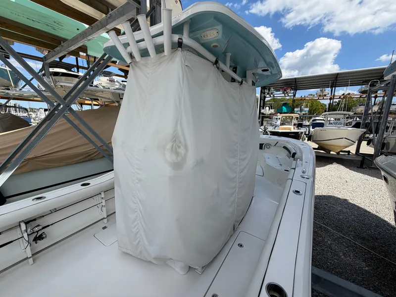 Slide: The Image of A 2021 Tidewater 272 CC Adventure with a cover over the helm, parked at the marina. - 18