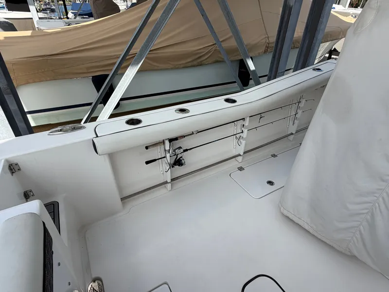 Slide: The Image of The image shows the cockpit of a 2021 Tidewater 272 CC Adventure boat with fishing rod holders. - 16