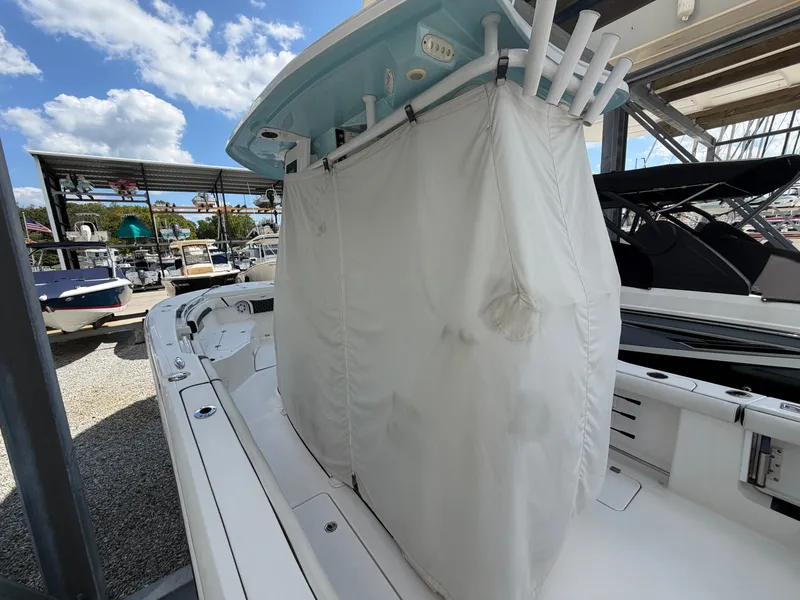 Slide: The Image of A 2021 Tidewater 272 CC Adventure with a white canopy and rod holders at the dock. - 19