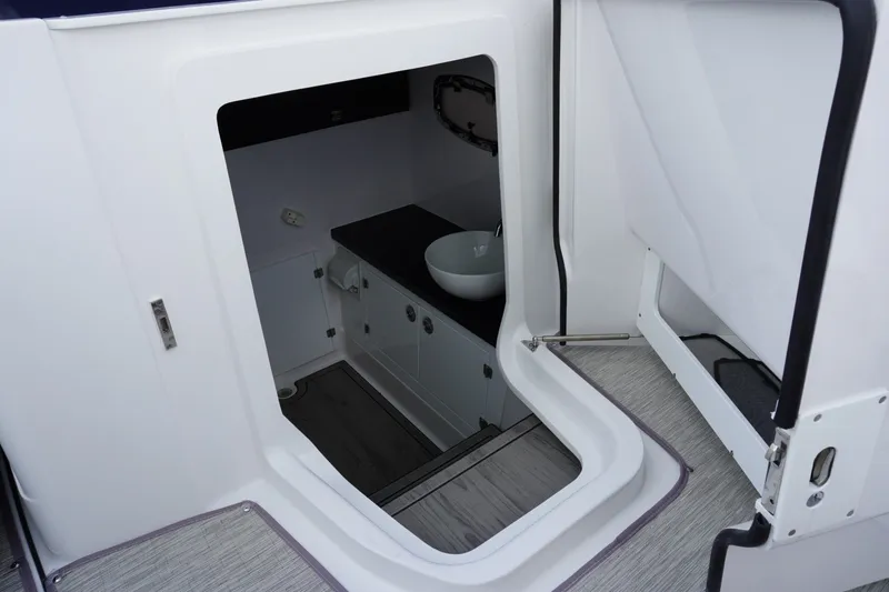 Slide: The Image of Interior view of 2027 Monterey Elite 30 OB boat, featuring a compact bathroom area. - 24