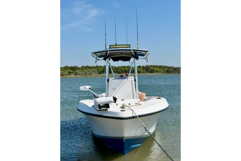 Slide: The Image of 2003 Contender 23 Open boat anchored in calm waters with fishing rods. - 1