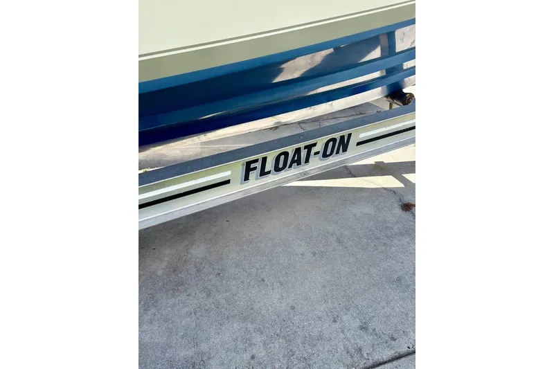 Slide: The Image of Trailer for 2003 Contender 23 Open boat with "FLOAT-ON" branding. - 16