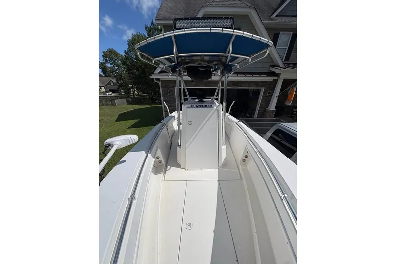 Slide: The Image of 2003 Contender 23 Open boat with blue canopy, parked in residential driveway. - 12