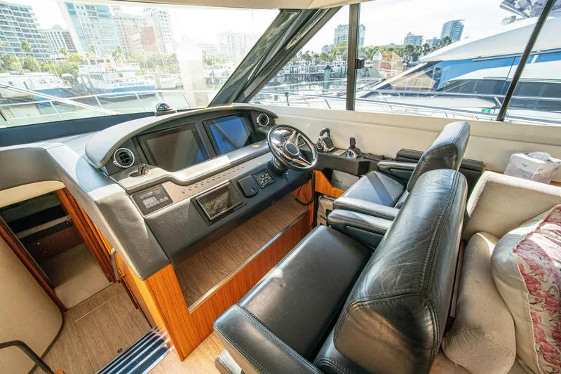 Slide: The Image of Interior of 2015 Riviera 6000 Sport Yacht helm with leather seating and modern controls. - 34