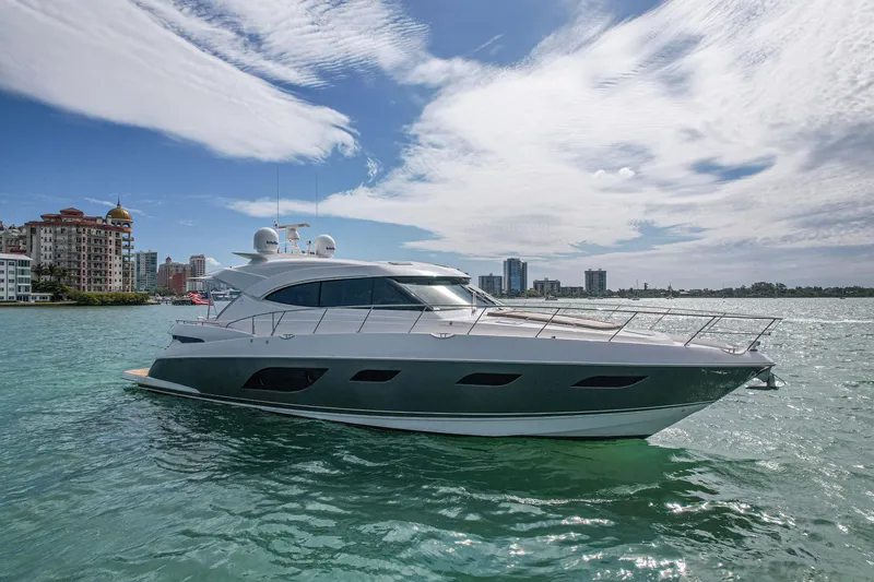 Slide: The Image of 2015 Riviera 6000 Sport Yacht on water with city skyline in background. - 6