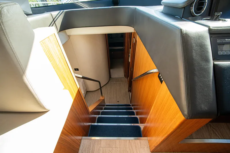 Slide: The Image of Interior stairs of 2015 Riviera 6000 Sport Yacht, featuring wood paneling and modern design. - 38