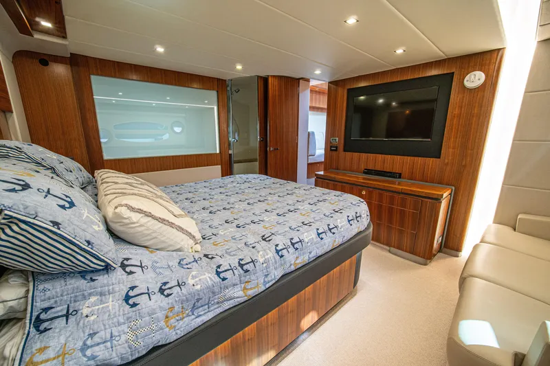 Slide: The Image of Luxurious 2015 Riviera 6000 Sport Yacht bedroom with nautical-themed bedding and modern amenities. - 51