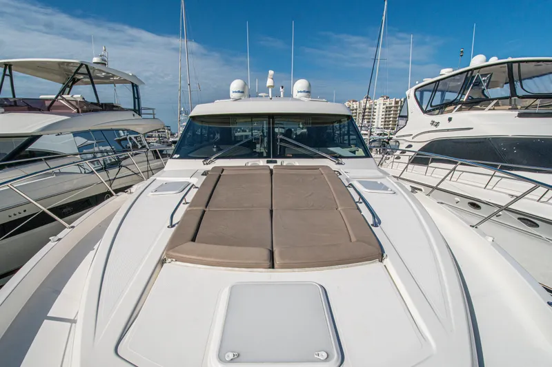 Slide: The Image of 2015 Riviera 6000 Sport Yacht docked among other luxury boats. - 63