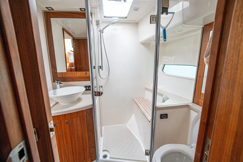 Slide: The Image of Luxurious bathroom in 2015 Riviera 6000 Sport Yacht with modern fixtures and wooden accents. - 45