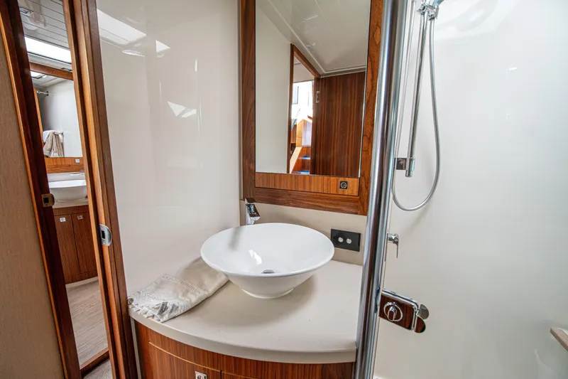 Slide: The Image of Luxurious bathroom interior of 2015 Riviera 6000 Sport Yacht with modern fixtures and wood accents. - 43