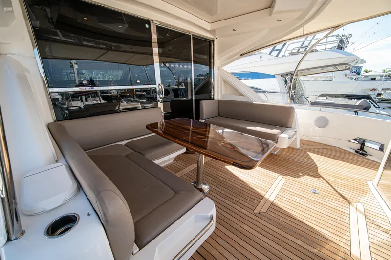 Slide: The Image of Luxurious 2015 Riviera 6000 Sport Yacht with elegant seating and polished wooden table. - 67