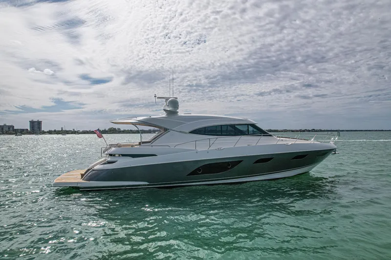 Slide: The Image of 2015 Riviera 6000 Sport Yacht cruising on calm waters under a cloudy sky. - 8