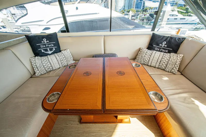Slide: The Image of Luxurious interior of 2015 Riviera 6000 Sport Yacht with elegant wooden table and plush seating. - 33