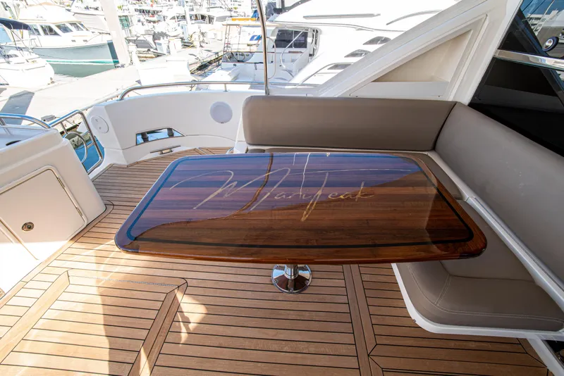 Slide: The Image of Luxurious 2015 Riviera 6000 Sport Yacht with elegant wooden table and seating area. - 24