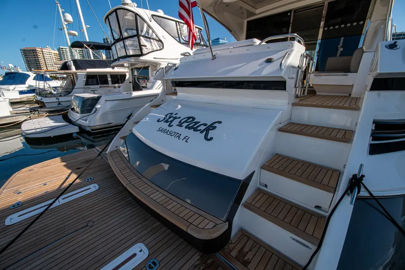 Slide: The Image of Luxury 2015 Riviera 6000 Sport Yacht docked, featuring elegant teak decking and sleek design. - 22