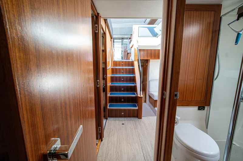 Slide: The Image of Interior view of 2015 Riviera 6000 Sport Yacht with wooden finishes and staircase. - 61
