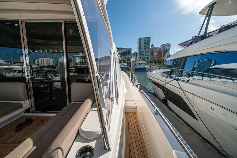 Slide: The Image of 2015 Riviera 6000 Sport Yacht docked at marina with city skyline. - 62