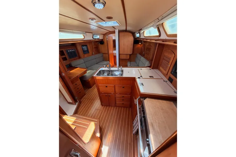 Slide: The Image of Interior of 2002 Sabre 362 sailboat featuring wood cabinetry, seating, and kitchen area. - 55