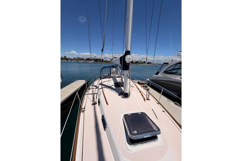 Slide: The Image of 2002 Sabre 362 sailboat docked, showcasing deck and mast under clear blue sky. - 23