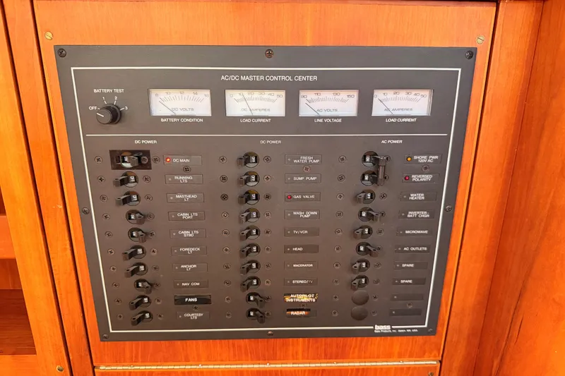Slide: The Image of AC/DC master control panel on a 2002 Sabre 362 yacht, featuring various switches and gauges. - 73