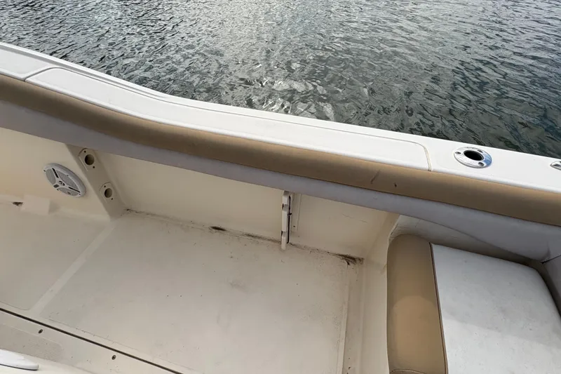 Slide: The Image of 2014 Scout 225 XSF boat interior with beige seating and water view. - 15