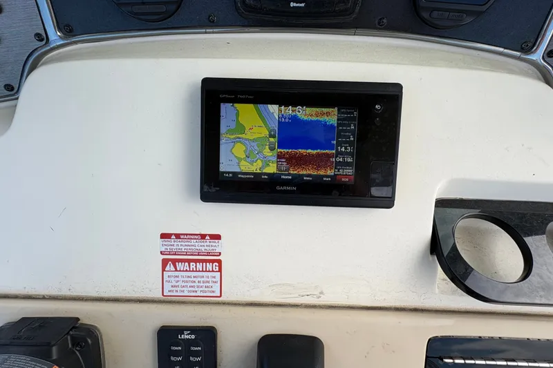 Slide: The Image of Garmin GPS display on 2014 Scout 225 XSF boat dashboard with warning labels. - 23
