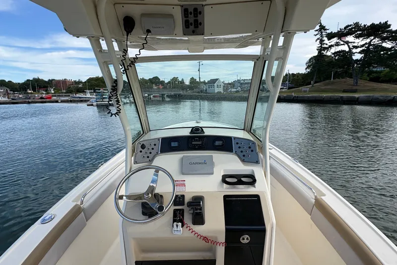 Slide: The Image of 2014 Scout 225 XSF boat dashboard with Garmin navigation, steering wheel, and water view. - 20