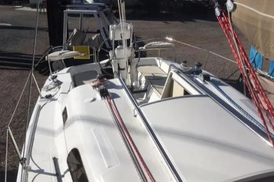 Slide: The Image of 2005 Hunter 27 sailboat with white deck and red rigging, docked in a marina. - 17