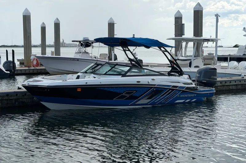 Slide: The Image of 2017 Monterey M-45 boat docked at marina with blue canopy and sleek design. - 1