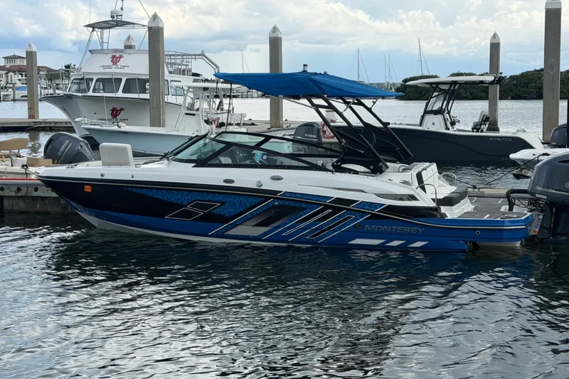 Slide: The Image of 2017 Monterey M-45 boat docked with blue canopy and sleek design. - 2