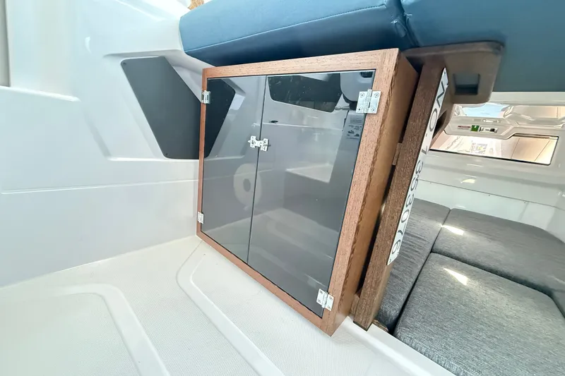 Slide: The Image of 2024 Axopar 29 XC Cross Cabin interior with wooden cabinet and seating area. - 13