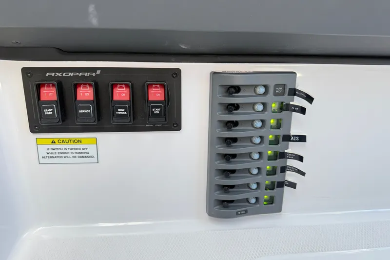 Slide: The Image of Control panel of 2024 Axopar 29 XC Cross Cabin with switches and caution label. - 20