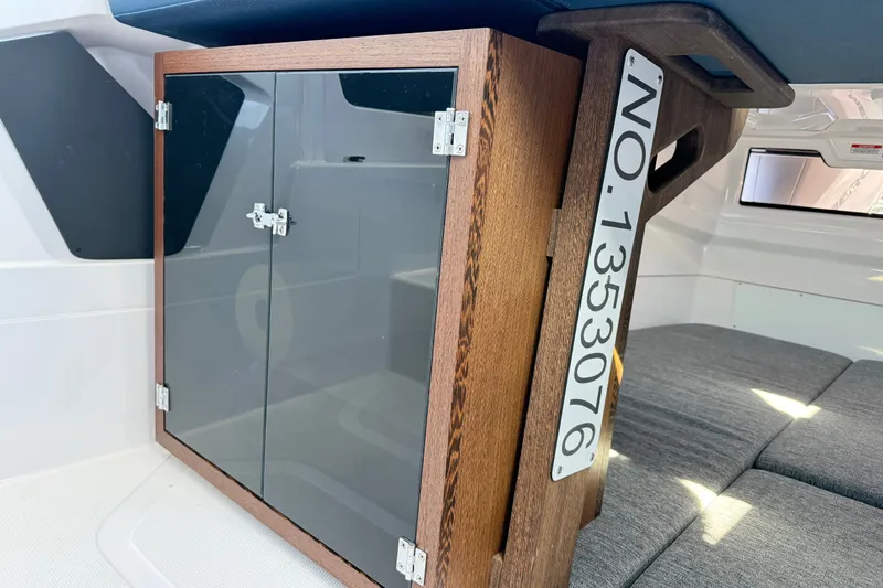 Slide: The Image of 2024 Axopar 29 XC Cross Cabin interior with wooden cabinet and seating area. - 12