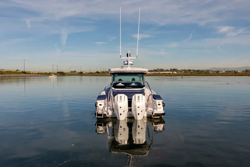 Slide: The Image of 2024 Axopar 29 XC Cross Cabin boat on calm water, rear view. - 3