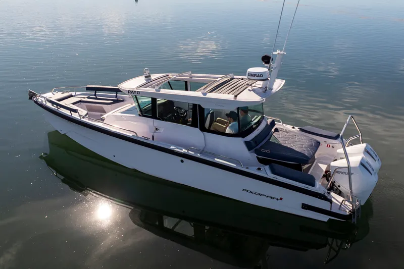Slide: The Image of 2024 Axopar 29 XC Cross Cabin boat on calm water, featuring sleek design and modern amenities. - 1