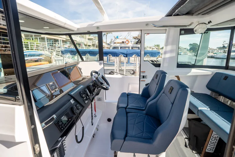 Slide: The Image of 2024 Axopar 29 XC Cross Cabin interior with modern dashboard and blue seating. - 8